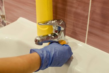 Temizleme ile temizlik banyo lavabo. Kadın banyo musluk temizler.