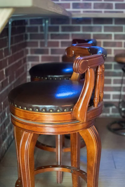 Cafe bar interior - wooden bar and bar chairs. Brown leather chairs near the bar counter.