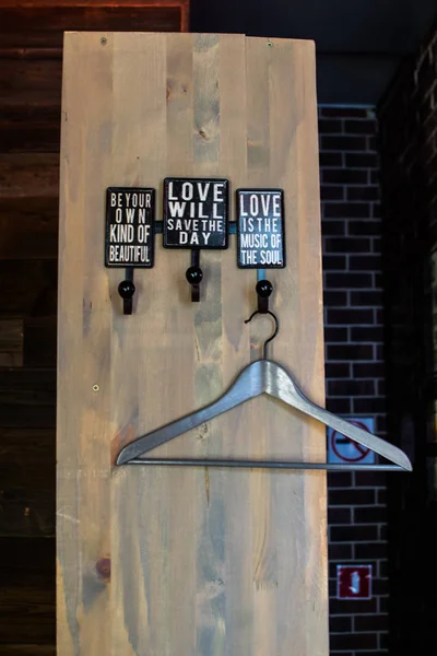 Coat hanger on wooden wall. Hooks for clothes on a wooden board.