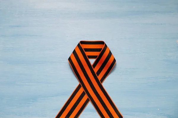 May 9, victory day, banner or poster. St. George striped ribbon on blue background.