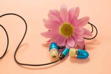 Güzel modern dijital plastik vakum mavi kulaklık pembe bir arka plan üzerinde müzik dinlemek için telleri ile.