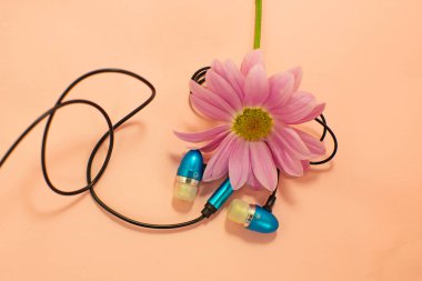 Güzel modern dijital plastik vakum mavi kulaklık pembe bir arka plan üzerinde müzik dinlemek için telleri ile.