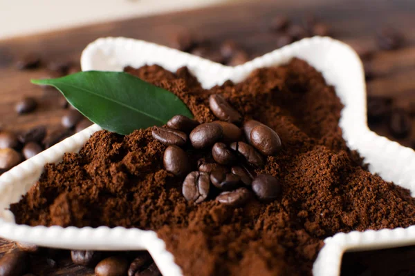 Bir ahşap tahta üzerinde beyaz bir kasede çekilmiş kahve.