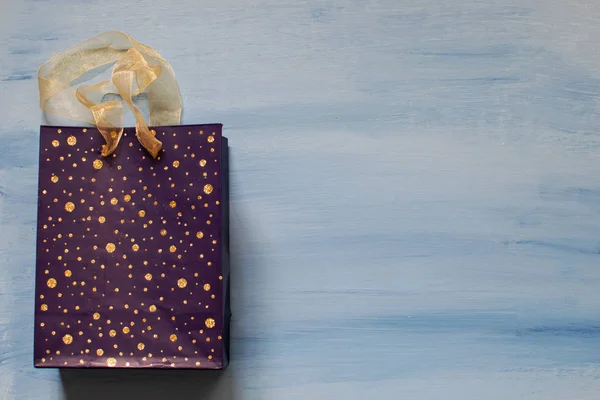 Sac cadeau violet sur fond bleu . — Photo