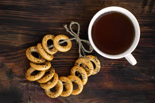 Bagels with cup of tea on a wooden board. — Stock Photo, Image