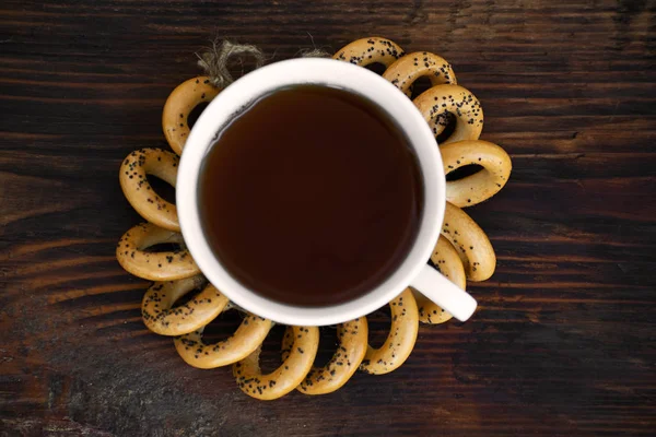Bagely s šálkem čaje na dřevěné desce. — Stock fotografie