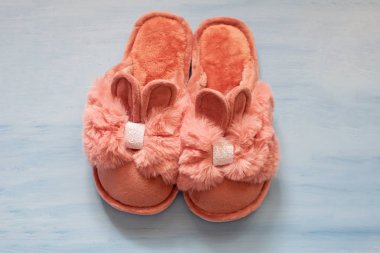 Mavi arka planda kulakları olan bir tavşan şeklinde terlikler.