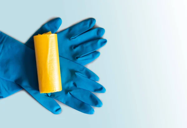 Желтые мешки для мусора и синие резиновые перчатки . — стоковое фото