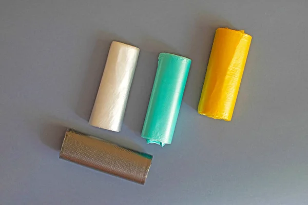 Χρωματιστά σακούλες σκουπιδιών ρολό σε γκρι φόντο — Φωτογραφία Αρχείου