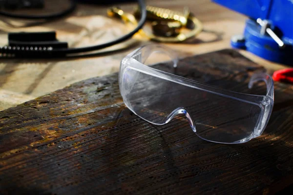 Ferramenta de artesão para homem trabalhador. Óculos de segurança na área de trabalho . — Fotografia de Stock