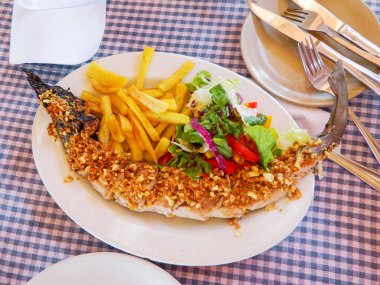 Fırında sarımsak, sebze ve patates kızartması ile köpekbalığı.