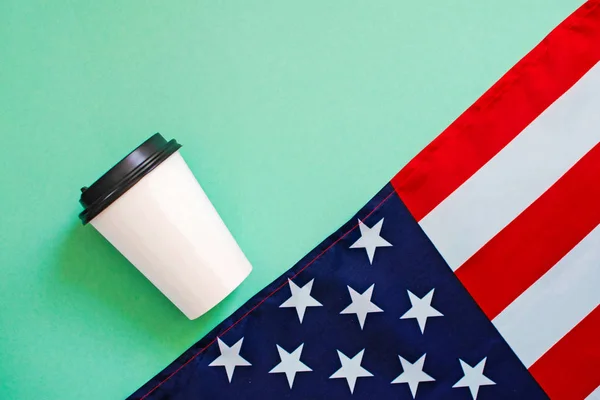 Bandeira americana e xícara de papel de café no fundo verde . — Fotografia de Stock