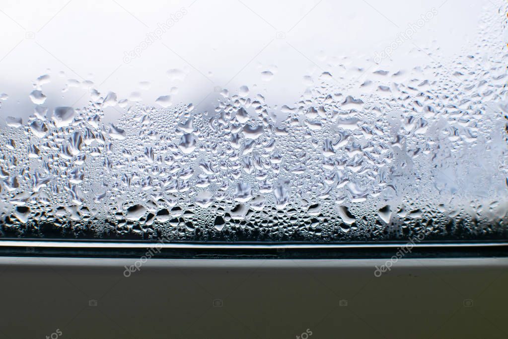 Raindrops on window panes in autumn. Condensate on the window.