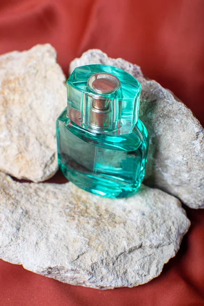 Butelka Perfum Brązowym Lub Czerwonym Tle Kamienie Naturalne Naturalne Składniki — Zdjęcie stockowe