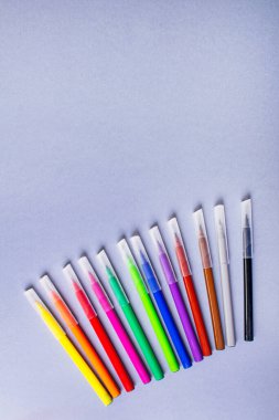 Gri arkaplandaki çok renkli keçeli kalemler veya işaretler.