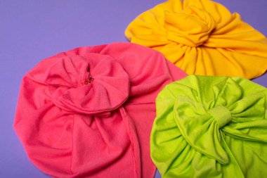 Üç sevimli çocuk saç bandı ya da leylak arka planda türban.