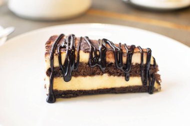 Kahve masasında beyaz tabakta lezzetli çikolatalı tiramisu dilimi. Geleneksel İtalyan bisküvisi ya da pasta.