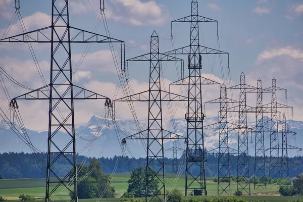 high voltage power lines and snow-covered mountains on horizon