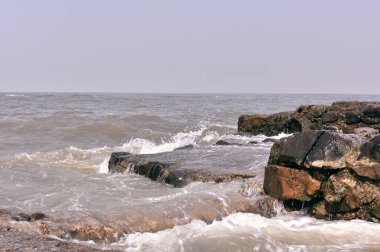 Deniz kıyısındaki büyük kayalara çarpan su.