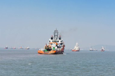 Mumbai 'deki engin mavi sularda yüzen turuncu bir kurtarma botu.