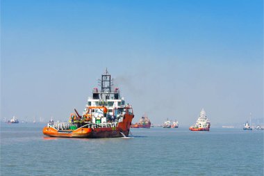 Güzel turuncu tekne mavi gökyüzüyle okyanusun ortasında duruyor.