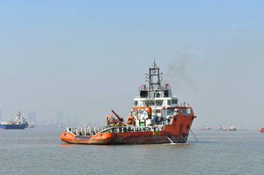 Mavi gökyüzünün altında okyanusun ortasında duran bir servis teknesi.