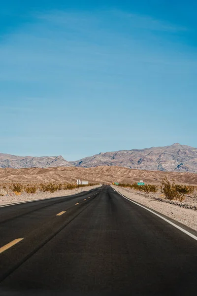 沙漠中的黑暗波浪形公路 死谷的公路在一片荒凉的褐色风景中 — 图库照片