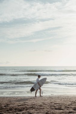 Bali adasında sörf yapan bir adamın minimalist fotoğrafı.