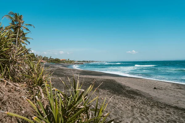 Endonezya, Bali 'de volkanik siyah kumlu, turistik olmayan bir plaj.