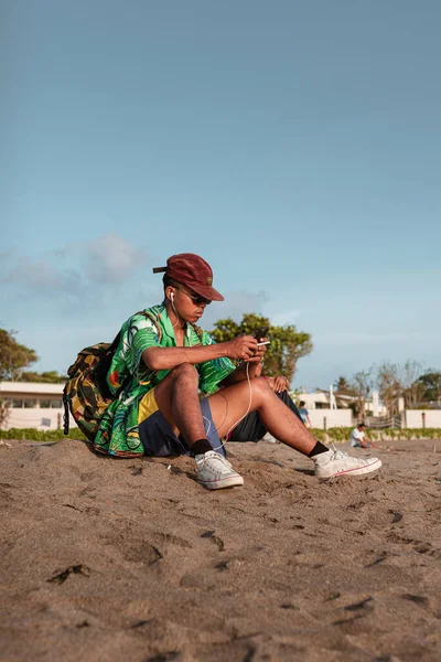 Asiatico Ragazzo Verde Camicia Cappello Siede Spiaggia Ascolta Musica Fotografia Stock