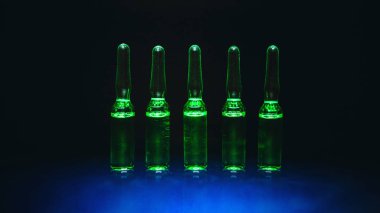 Tıbbi preparatlar. hastalıkların tedavisi için. ampul siyah bir zemin üzerine yeşil sıvı ile. sanatsal karanlık filtre. düşük anahtar fotoğraf