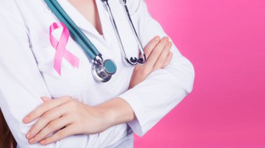 Pembe bir arka plan üzerinde pembe kurdele ile kadın doktor. Kanser hastalarına destek kavramı.