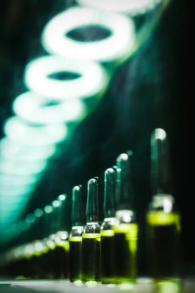 Concept ontwikkeling van de productie van medische producten. Bright flesjes met lumineuze groene inhoud: vergif, doping, zuur, chemie, antibiotica, sedativa, Narcotic drugs. lage hoofdfoto — Stockfoto