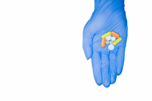 Mão na luva segurando pílulas no fundo branco isolado — Fotografia de Stock