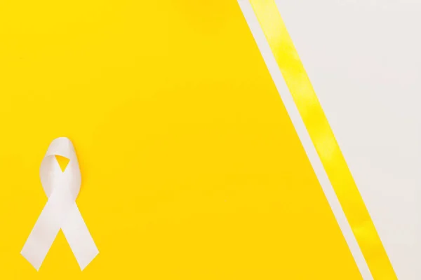 Biała wstążka świadomości koncepcji dnia aids. żółto niebieskie tło — Zdjęcie stockowe