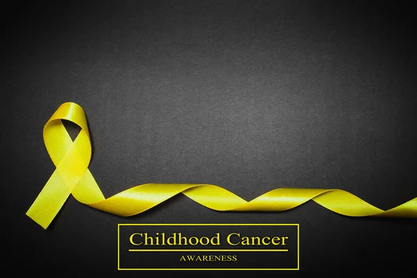 Journée de sensibilisation au cancer chez les enfants. Ruban jaune sur fond noir — Photo