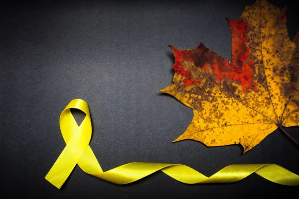 Journée de sensibilisation au cancer chez les enfants. Ruban jaune sur fond noir . — Photo