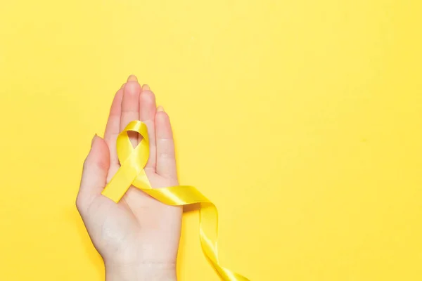 여성 손 컬러 바탕에 노란 리본을 들고입니다. 암 개념 스톡 이미지