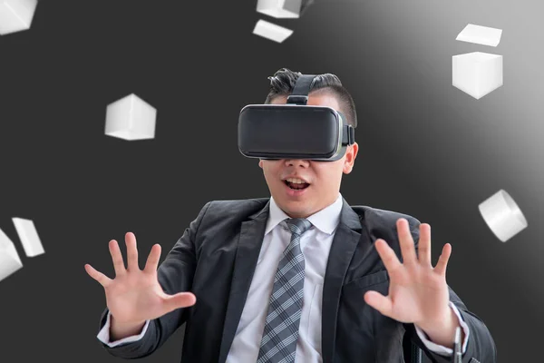 Young Asian businessman playing VR In a fun and exciting way to see virtual reality. The concept of visual reality using or experience using VR glasses is popular in Asia