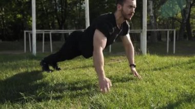 Sakallı güçlü kaslı vücut geliştirici ısınıyor, genç sporcu yerden sıkıyor..