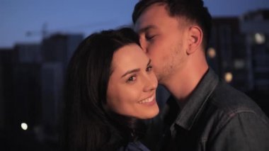 Mutlu genç çift, gülümsüyor ve öpüşüyorlar..