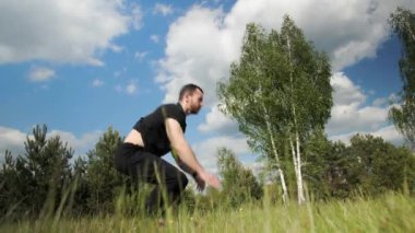 Sakallı güçlü kaslı atlet ısınıyor, genç sporcu stadyumda geğiriyor..