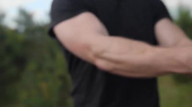 Güçlü eğitim kavramı. Güçlü adam lastik kullanarak egzersiz yapıyor, vücut geliştirici dışarıda lastik çalışıyor, yakın plan eller..