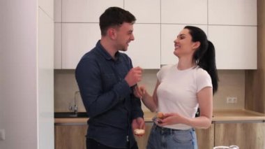 Genç çift modern beyaz mutfakta eğleniyor..