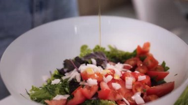 Karım zeytinyağı, marul, domates ve salatalıklı taze vejetaryen salatası yapıyor..