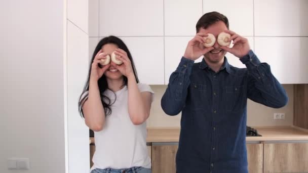 Mari et femme s'amusent dans la cuisine moderne.Légumes au premier plan . — Video