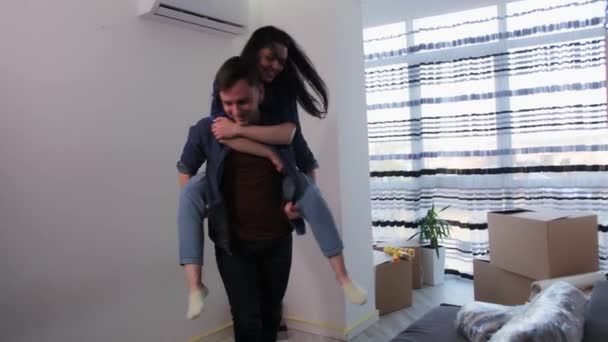 La coppia si sta divertendo in un nuovo appartamento.Ristrutturazioni in camera a casa . — Video Stock