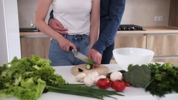 Flicka med kniv skivning färsk gurka på köksbord under matlagning. — Stockvideo