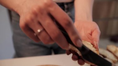 Güzel bir eş beyaz bir mutfağa tereyağıyla baget sürer..