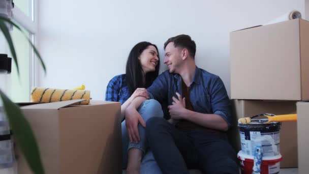 Coppia ragazza e ragazzo seduto sul pavimento tra le scatole . — Video Stock